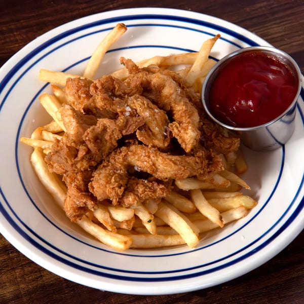 Crispy fried chicken tenders and golden french fries with a side of ketchup on a white plate.
